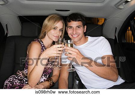 Stock Photo - Couple celebrating in the back of a car. Fotosearch