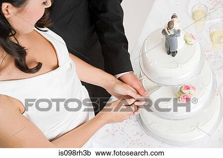 Bride and groom cutting a wedding cake View Large Photo Image Stock Image - Bride and groom cutting a wedding cake. Fotosearch