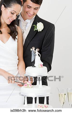 Bride and groom cutting a wedding cake View Large Photo Image Stock Image - Bride and groom cutting a wedding cake. Fotosearch