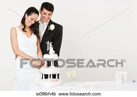 Bride and groom cutting a wedding cake View Large Photo Image Stock Image - Bride and groom cutting a wedding cake. Fotosearch