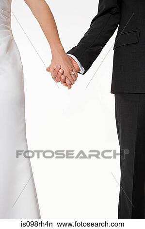 Bride and groom holding hands View Large Photo Image Picture - Bride and groom holding hands. Fotosearch