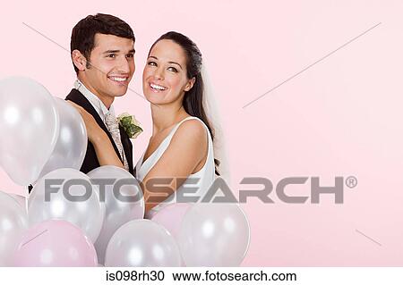 Bride and groom with a bunch of balloons View Large Photo Image Stock Image - Bride and groom with a bunch of balloons. Fotosearch