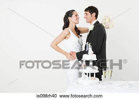 Stock Image - Bride and groom with a wedding cake. Fotosearch