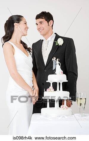 Stock Image - Bride and groom with wedding cake. Fotosearch