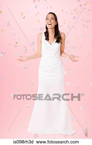 Bride standing beneath falling confetti View Large Photo Image Stock Image - Bride standing beneath falling confetti. Fotosearch