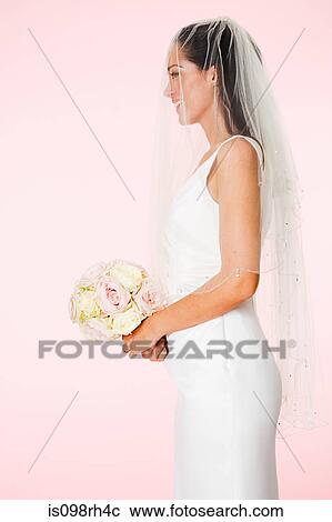 Stock Image - Side view of a bride holding a bouquet. Fotosearch