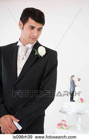 Worried looking groom with wedding cake View Large Photo Image Stock Photo - Worried looking groom with wedding cake. Fotosearch