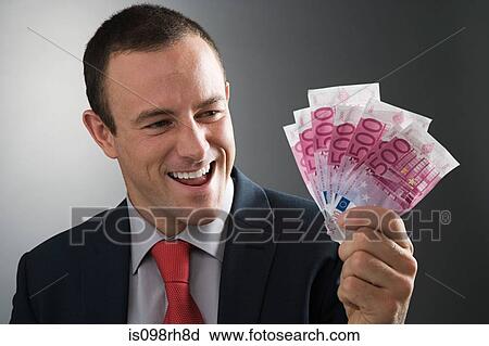 Stock Image - Businessman holding bank notes. Fotosearch