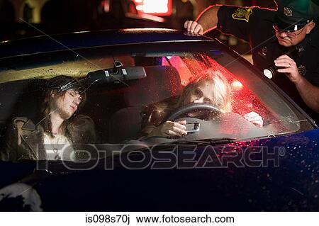 Stock Image - Police officer looking at crashed car. Fotosearch