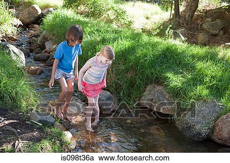 Boy and girl walking in river View Large Photo Image Stock Image - Boy and girl walking in river. Fotosearch