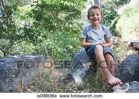Boy sitting on rock View Large Photo Image Stock Image - Boy sitting on rock. Fotosearch