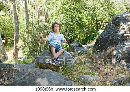 Boy sitting on rock View Large Photo Image Stock Image - Boy sitting on rock. Fotosearch
