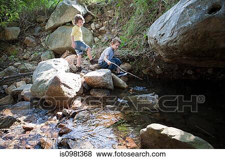 Boys on rocks by river View Large Photo Image Stock Photo - Boys on rocks by river. Fotosearch