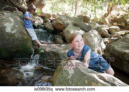 Stock Photography - Children on rocks by river. Fotosearch