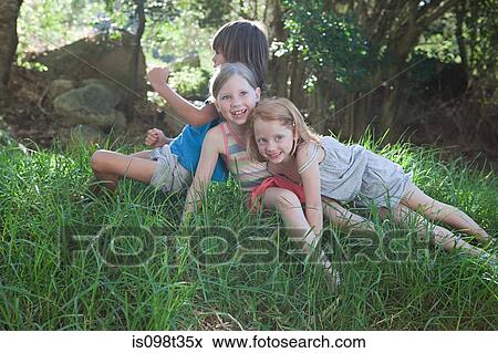 Stock Photo - Children sitting on grass. Fotosearch