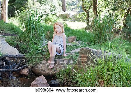 Girl on rocks by river View Large Photo Image Picture - Girl on rocks by river. Fotosearch