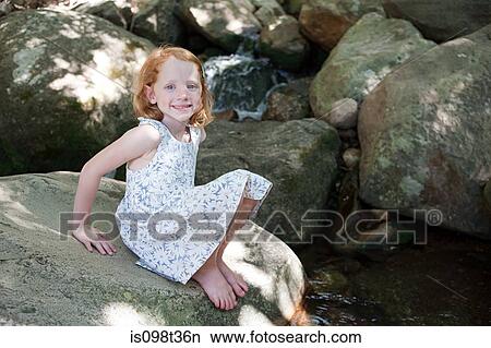 Girl on rocks by river View Large Photo Image Picture - Girl on rocks by river. Fotosearch