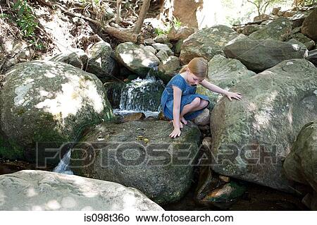Girl on rocks by river View Large Photo Image Picture - Girl on rocks by river. Fotosearch