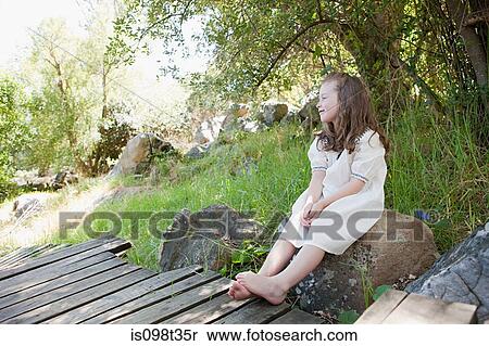 Girl sitting on rock View Large Photo Image Stock Photography - Girl sitting on rock. Fotosearch