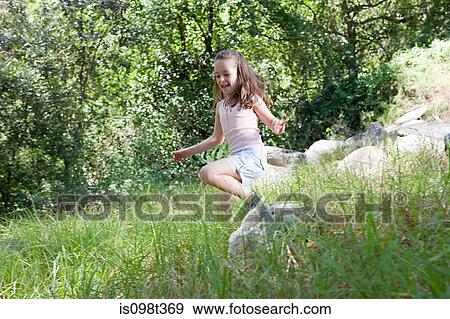 Stock Photo - Girl skipping through grass. Fotosearch