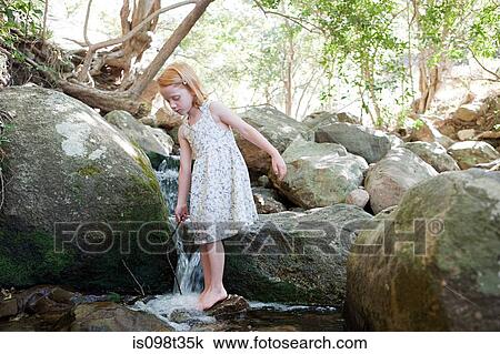 Girl standing on rock in river View Large Photo Image Stock Image - Girl standing on rock in river. Fotosearch