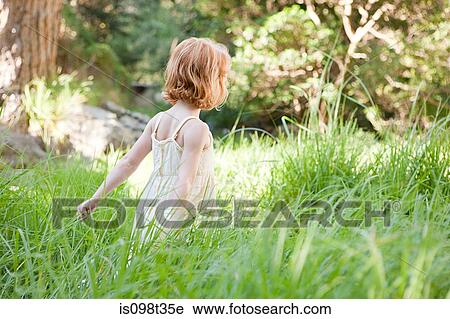 Little girl in field of grass View Large Photo Image Stock Image - Little girl in field of grass. Fotosearch