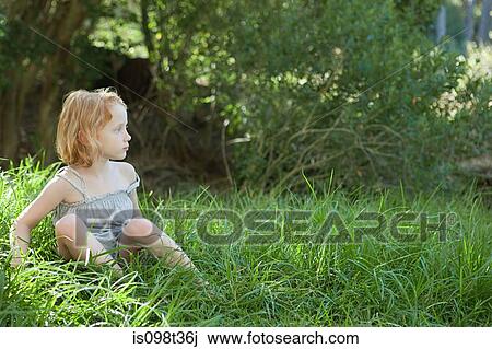 Little girl sitting in grass View Large Photo Image Stock Image - Little girl sitting in grass. Fotosearch