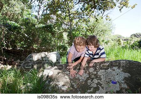 Two boys leaning on rock View Large Photo Image Stock Photograph - Two boys leaning on rock. Fotosearch