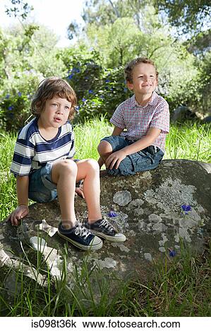 Stock Image - Two boys sitting on a rock. Fotosearch