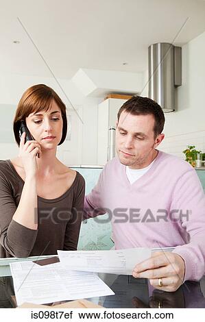 Couple on telephone with bills View Large Photo Image Stock Image - Couple on telephone with bills. Fotosearch