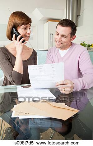 Couple on telephone with bills View Large Photo Image Stock Photography - Couple on telephone with bills. Fotosearch