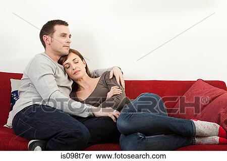 Couple relaxing on sofa View Large Photo Image Stock Photography - Couple relaxing on sofa. Fotosearch