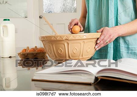 Woman breaking egg into bowl View Large Photo Image Stock Photo - Woman breaking egg into bowl. Fotosearch