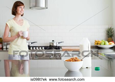 Stock Image - Woman in kitchen at breakfast. Fotosearch