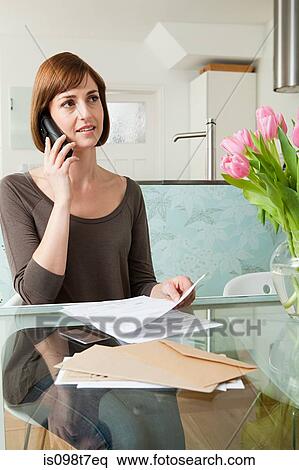 Stock Photography - Woman on telephone with bills. Fotosearch