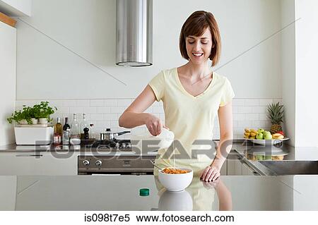 Woman pouring milk onto cereal View Large Photo Image Stock Photography - Woman pouring milk onto cereal. Fotosearch