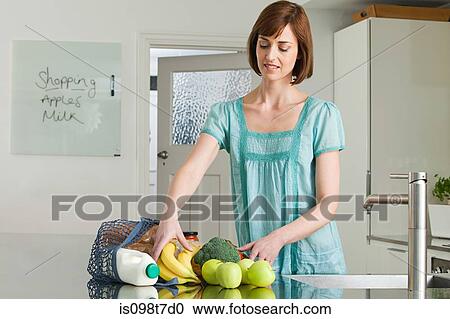 Woman unpacking groceries View Large Photo Image Stock Image - Woman unpacking groceries. Fotosearch