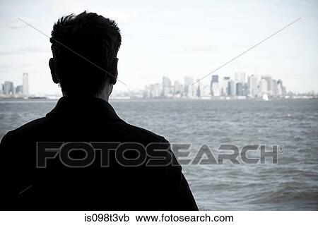 Man looking over river to manhattan View Large Photo Image Stock Image - Man looking over river to manhattan. Fotosearch