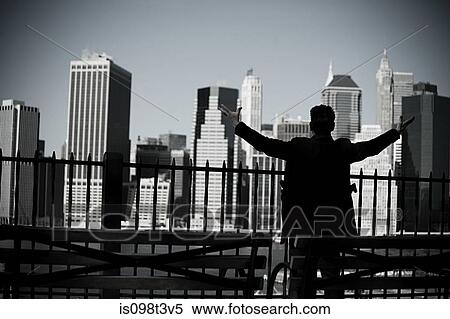 Stock Photography - Man with arms open and view of lower manhattan. Fotosearch
