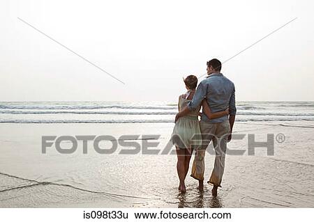 Couple looking out to the ocean View Large Photo Image Stock Photograph - Couple looking out to the ocean. Fotosearch