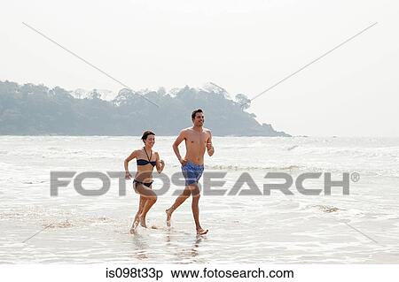 Couple running in the sea View Large Photo Image Stock Photography - Couple running in the sea. Fotosearch
