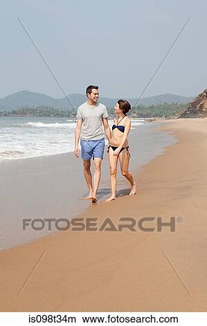 Couple walking by the ocean View Large Photo Image Picture - Couple walking by the ocean. Fotosearch