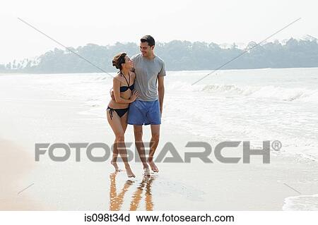 Couple walking by the ocean View Large Photo Image Stock Image - Couple walking by the ocean. Fotosearch