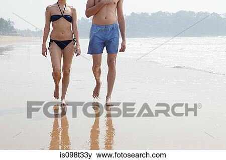 Couple walking by the ocean View Large Photo Image Stock Photo - Couple walking by the ocean. Fotosearch