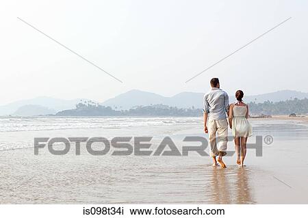 Couple walking in the sea View Large Photo Image Stock Image - Couple walking in the sea. Fotosearch