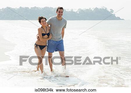 Couple walking in the sea View Large Photo Image Stock Image - Couple walking in the sea. Fotosearch