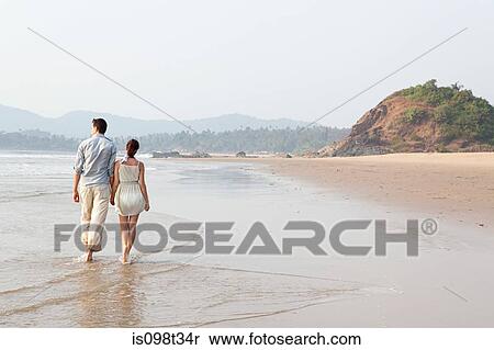 Stock Photography - Couple walking in the sea. Fotosearch