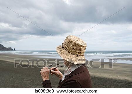 Stock Image - Senior woman on Piha Beach, Auckland. Fotosearch