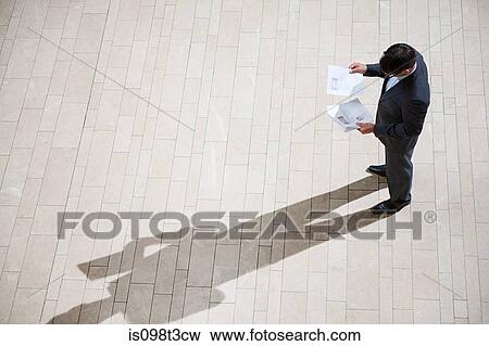 Businessman looking at paperwork View Large Photo Image Stock Photo - Businessman looking at paperwork. Fotosearch