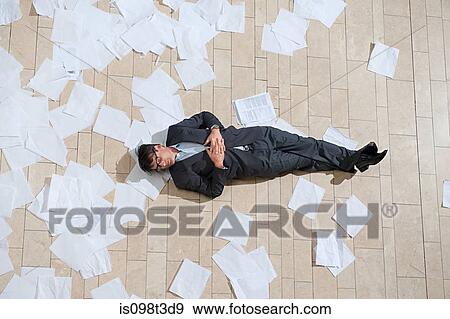 Businessman lying on floor with scattered papers View Large Photo Image Stock Photo - Businessman lying on floor with scattered papers. Fotosearch